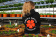 Romence Gardens Logo Hoodie back being worn in greenhouse